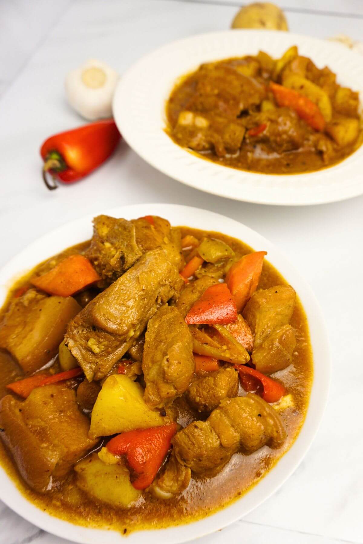 Pork caldereta in plates on top view.