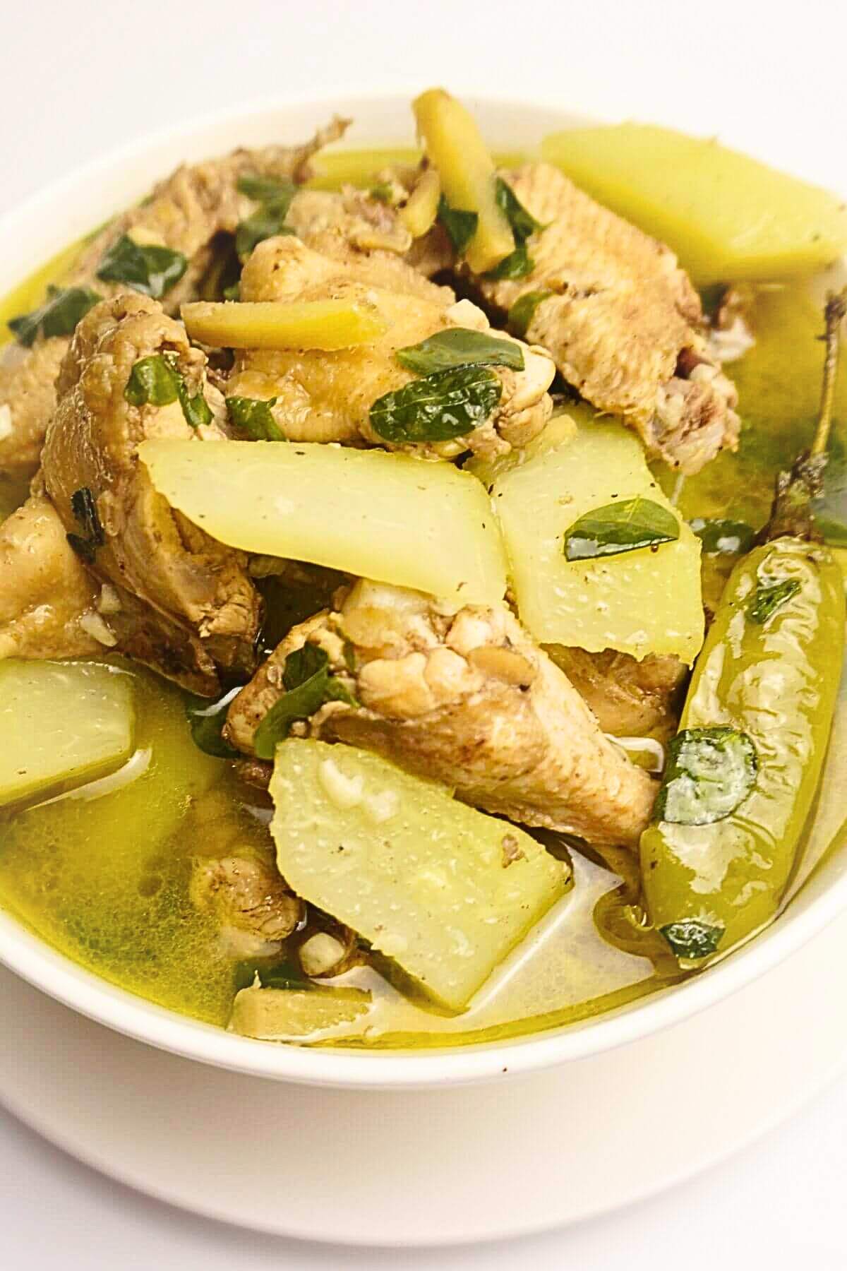 Chicken tinola in a white bowl.