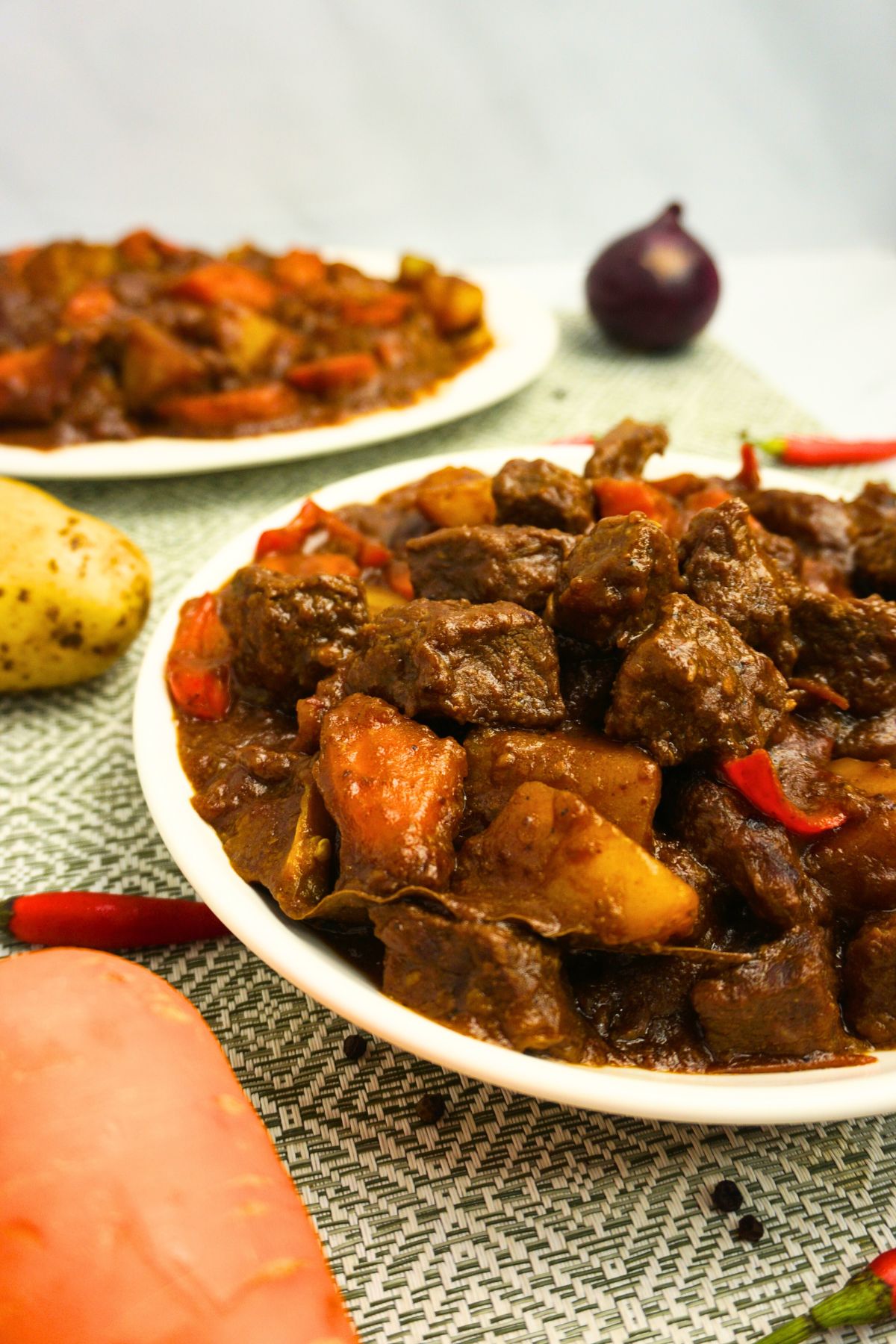 Beef stew made with tender beef, potatoes, carrots, and bell peppers, all simmered in a savory tomato sauce.