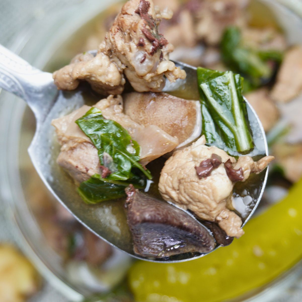 Spoon scooping pork liver, spleen and blood on a bowl of batchoy.