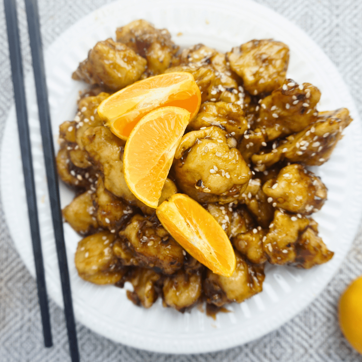 Fried chicken cubes coated in flour with orange sauce.