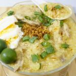Bowl of arroz caldo with fresh calamansi.