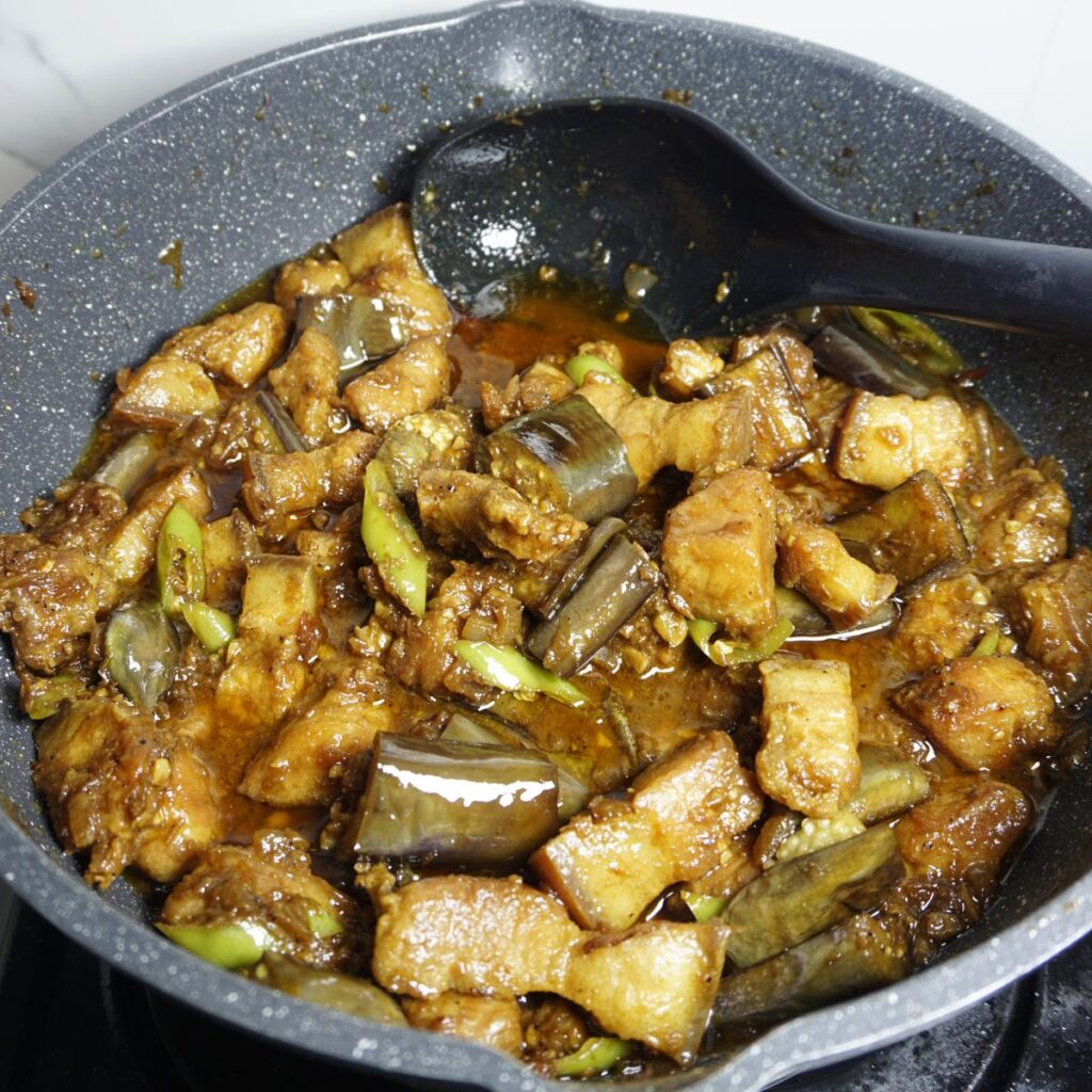 Pork binagoongan cooked in a pan.