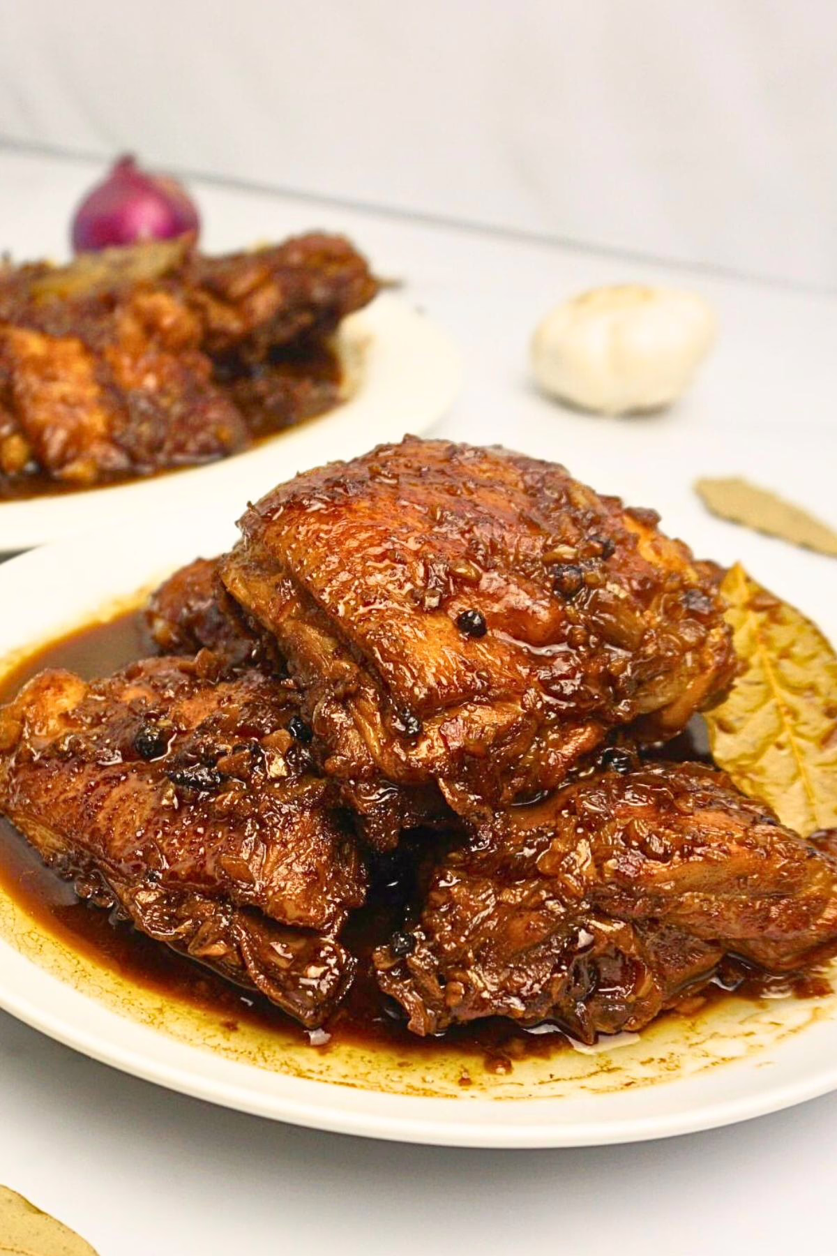 Chicken adobo served in a white plate.